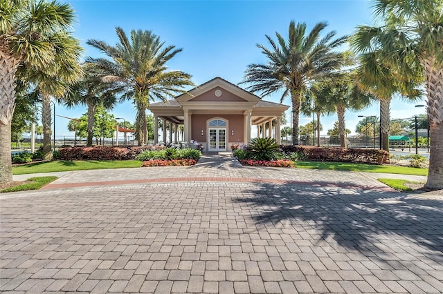 view of front of house featuring french doors, stucco siding, and fence