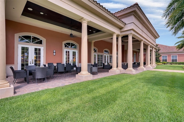 rear view of property with a patio area, outdoor lounge area, french doors, a yard, and stucco siding