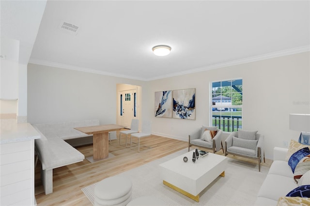 living room featuring light wood-type flooring and ornamental molding