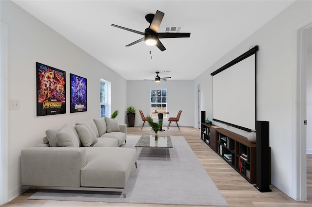 living room with ceiling fan, light wood finished floors, and visible vents