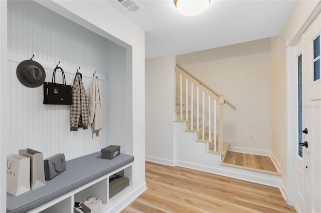 mudroom featuring visible vents, baseboards, and wood finished floors