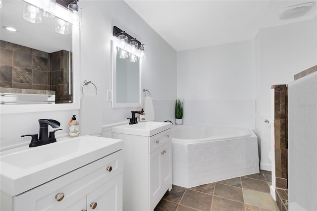 bathroom featuring tile patterned floors, vanity, and tiled tub