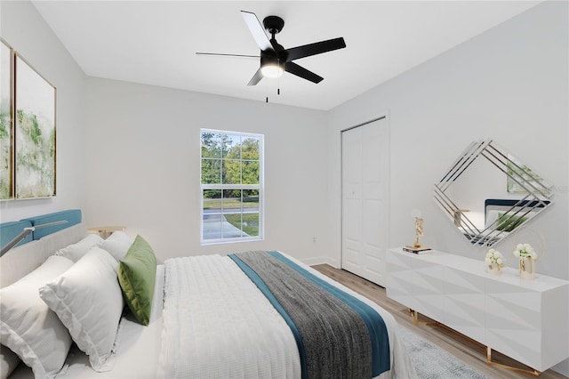 bedroom with hardwood / wood-style floors, a closet, and ceiling fan