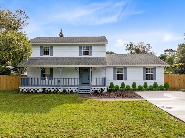 traditional home with a front yard, covered porch, roof with shingles, and fence