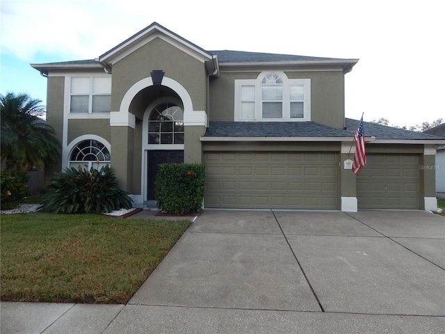 view of property featuring a garage and a front lawn