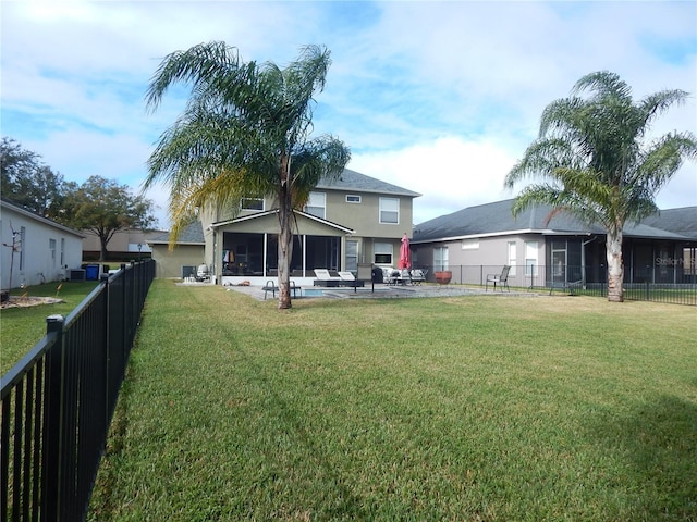 rear view of property featuring a lawn, a patio area, and a sunroom