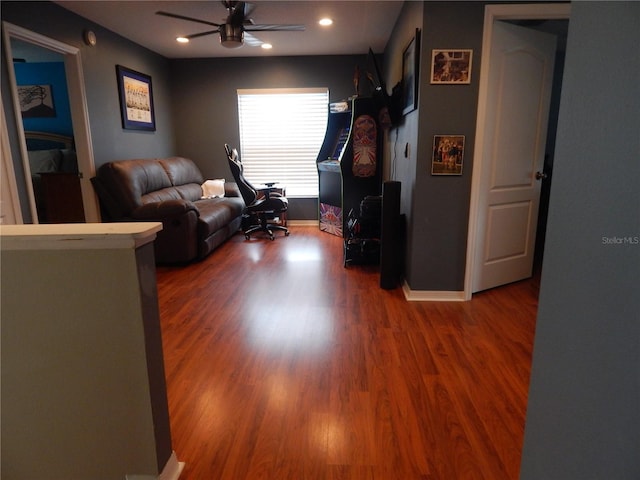 living room with wood-type flooring and ceiling fan