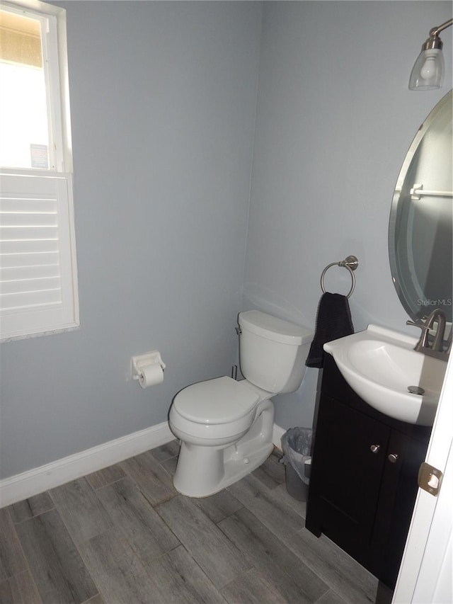 bathroom with wood-type flooring, vanity, and toilet