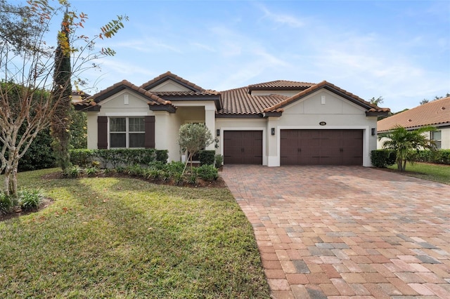 mediterranean / spanish home featuring a garage and a front yard