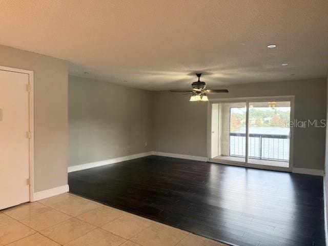 spare room with ceiling fan and light wood-type flooring