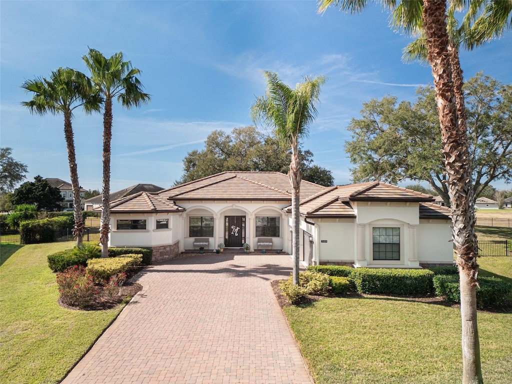 mediterranean / spanish home with a front lawn