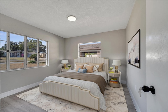 bedroom featuring wood-type flooring and a textured ceiling