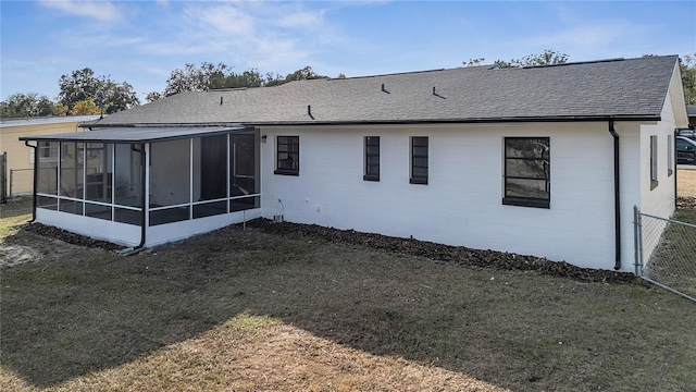 rear view of property with a yard and a sunroom