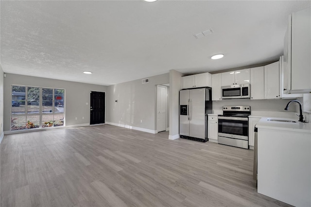 kitchen featuring white cabinetry, stainless steel appliances, light hardwood / wood-style floors, and sink