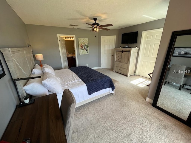 bedroom featuring light carpet, a textured ceiling, ensuite bathroom, and ceiling fan