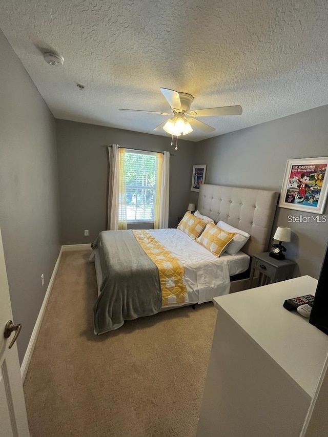 carpeted bedroom featuring a textured ceiling and ceiling fan