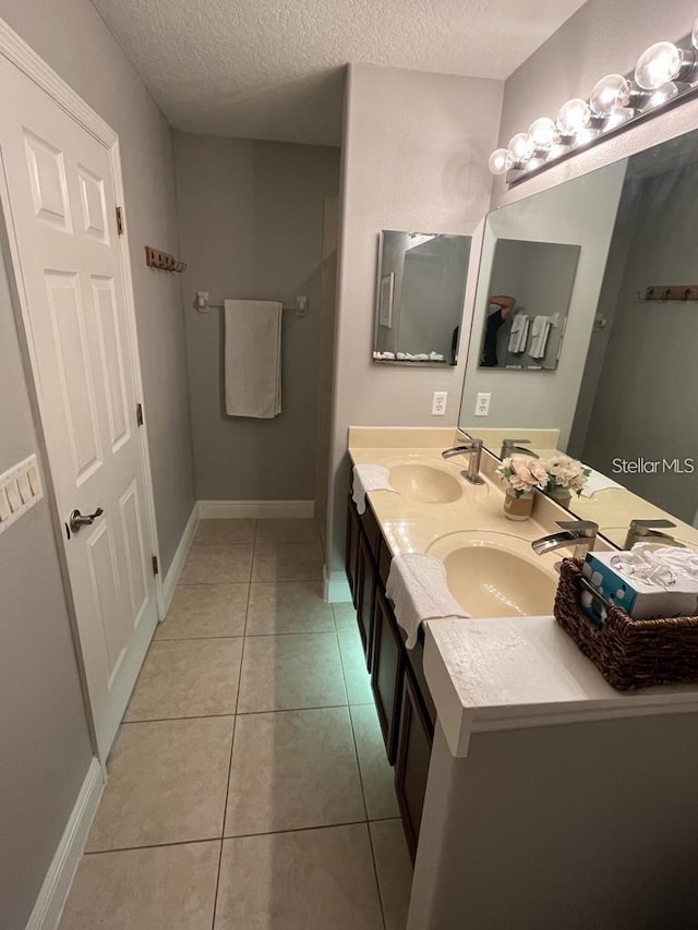 bathroom featuring tile patterned flooring, vanity, and a textured ceiling