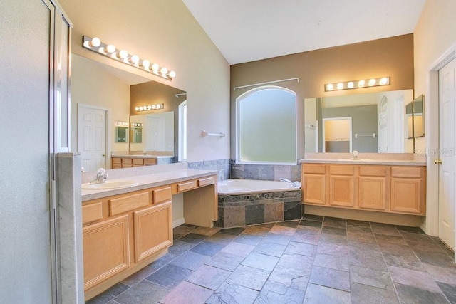 bathroom featuring vanity and a relaxing tiled tub