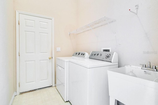 washroom with washer and dryer and sink