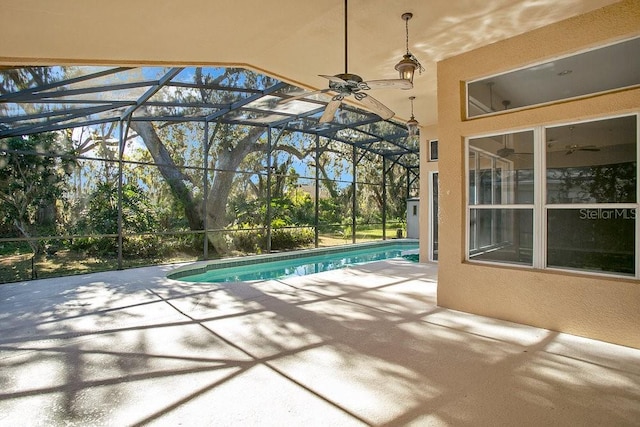 view of pool with a patio, ceiling fan, and a lanai