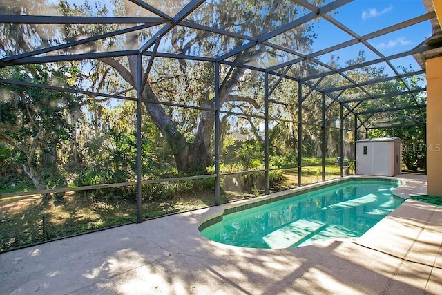 view of pool with a lanai, a patio, and a storage shed