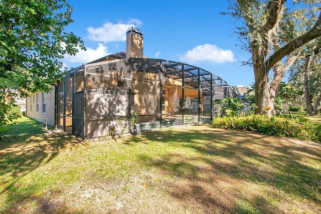 back of house with a lanai, a lawn, and a swimming pool