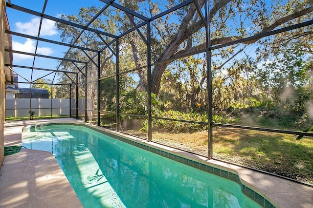 view of swimming pool featuring glass enclosure