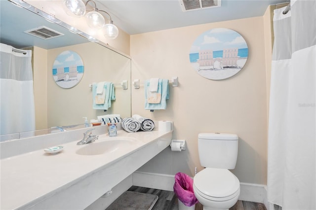 bathroom with sink, hardwood / wood-style floors, and toilet