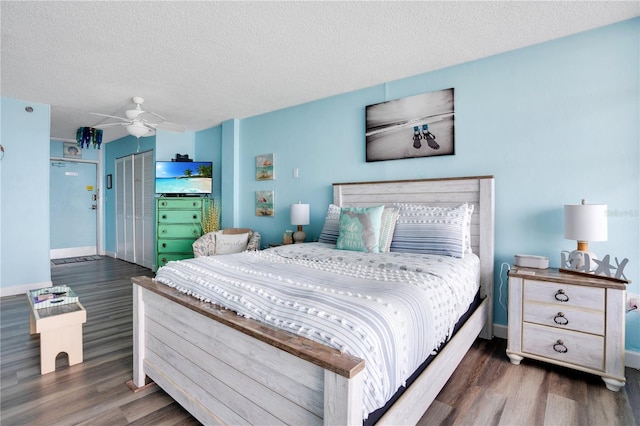 bedroom featuring ceiling fan, dark hardwood / wood-style flooring, a textured ceiling, and a closet