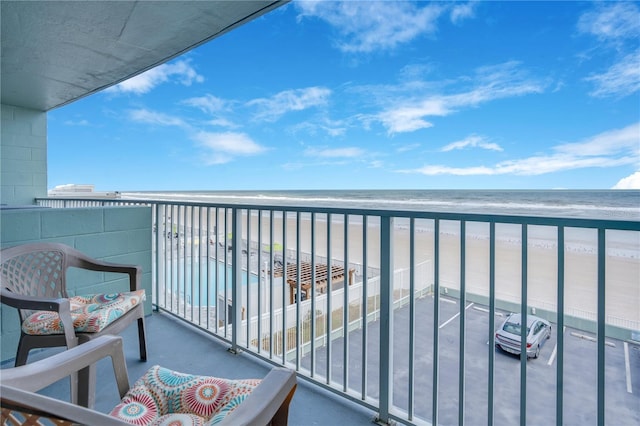 balcony featuring a water view and a beach view