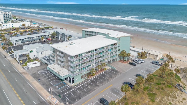 drone / aerial view with a water view and a beach view