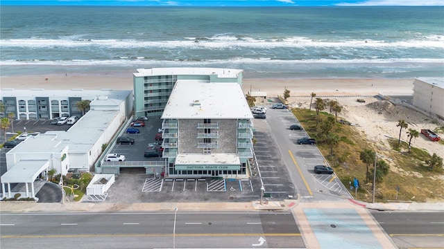 birds eye view of property featuring a beach view and a water view