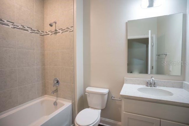 full bathroom featuring vanity, tiled shower / bath combo, and toilet