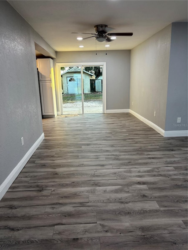 unfurnished room featuring ceiling fan and dark wood-type flooring