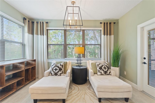 sitting room featuring an inviting chandelier and baseboards