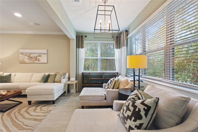 living room with an inviting chandelier, visible vents, and crown molding