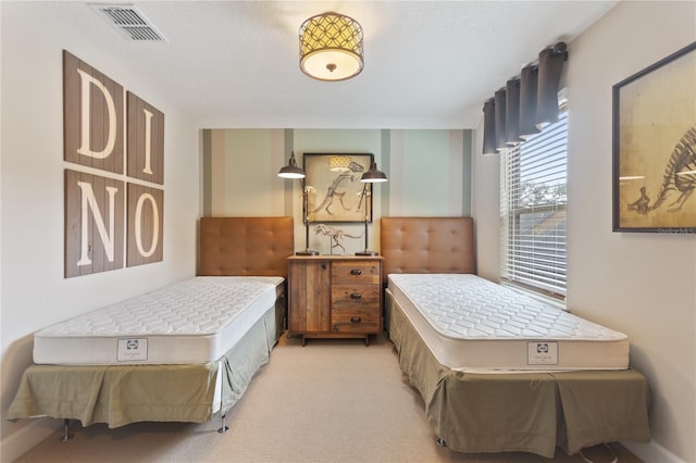 bedroom featuring visible vents and light colored carpet