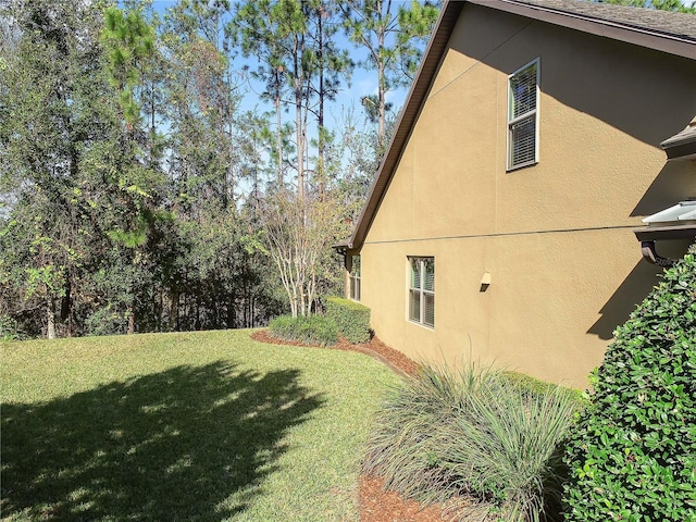 view of home's exterior with a lawn and stucco siding