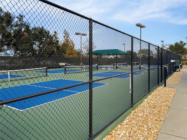 view of tennis court featuring fence