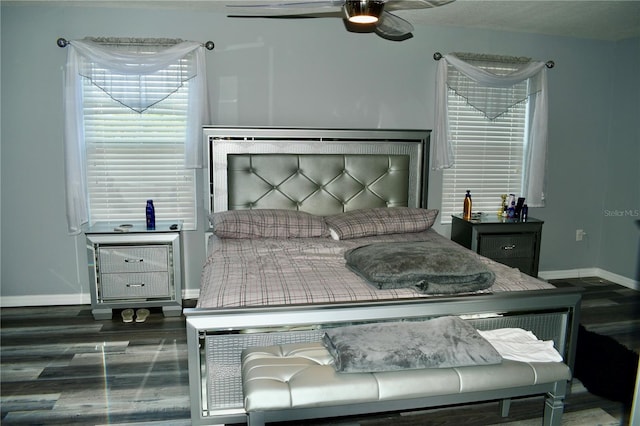 bedroom with a textured ceiling, ceiling fan, and dark hardwood / wood-style floors