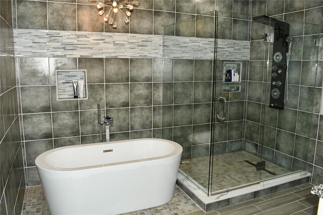 bathroom with tile walls and independent shower and bath