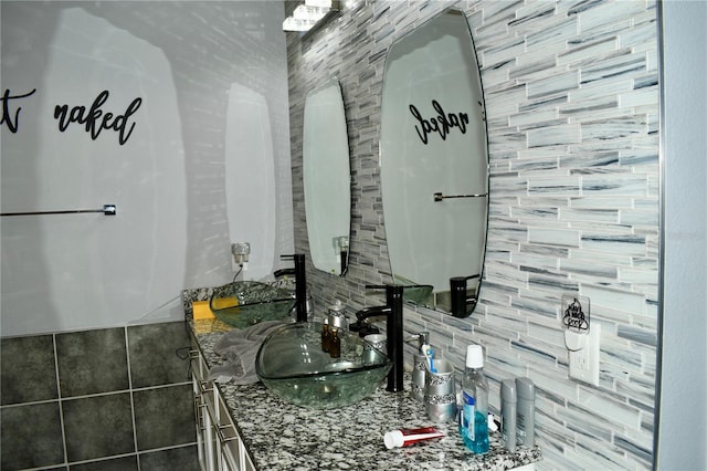 bathroom with decorative backsplash, tile walls, and vanity