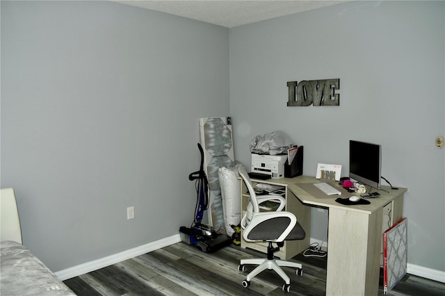 home office featuring a textured ceiling and dark wood-type flooring