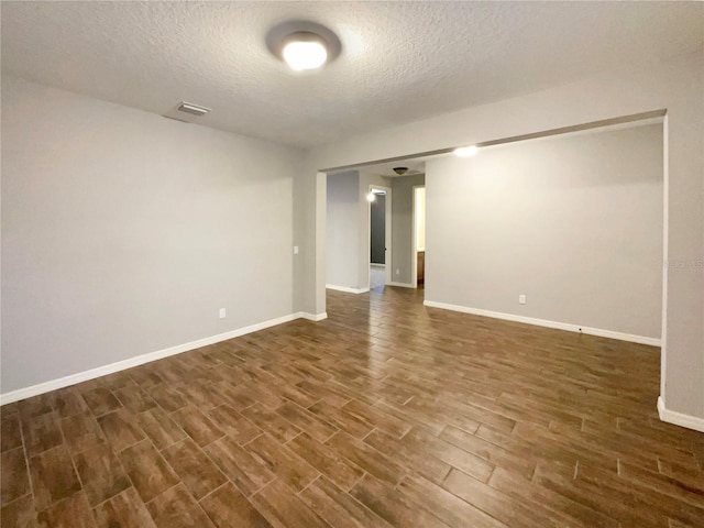 spare room with dark hardwood / wood-style flooring and a textured ceiling