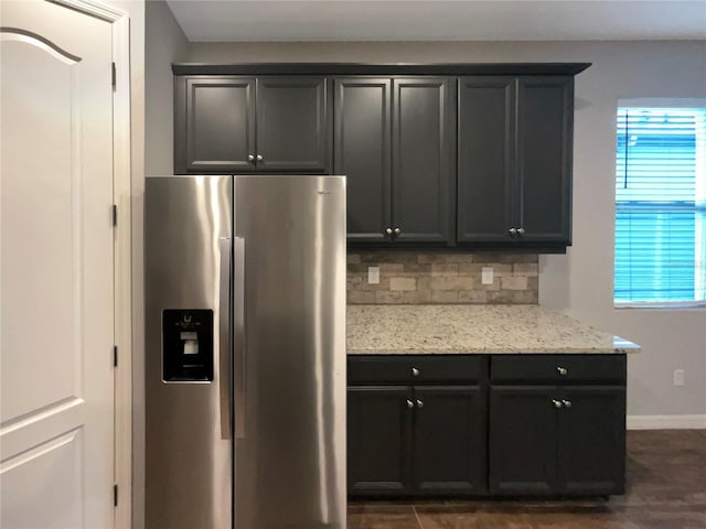 kitchen featuring decorative backsplash, light stone countertops, and stainless steel fridge with ice dispenser