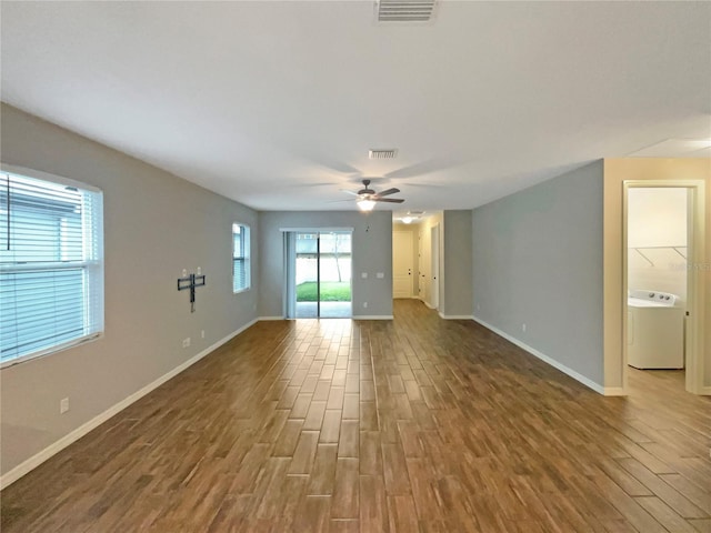 unfurnished room featuring washer / dryer, hardwood / wood-style flooring, and ceiling fan