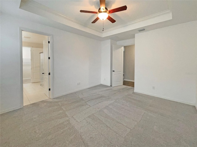 carpeted empty room featuring a tray ceiling, crown molding, and ceiling fan