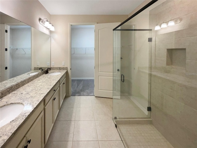 bathroom featuring tile patterned floors, vanity, and a shower with shower door