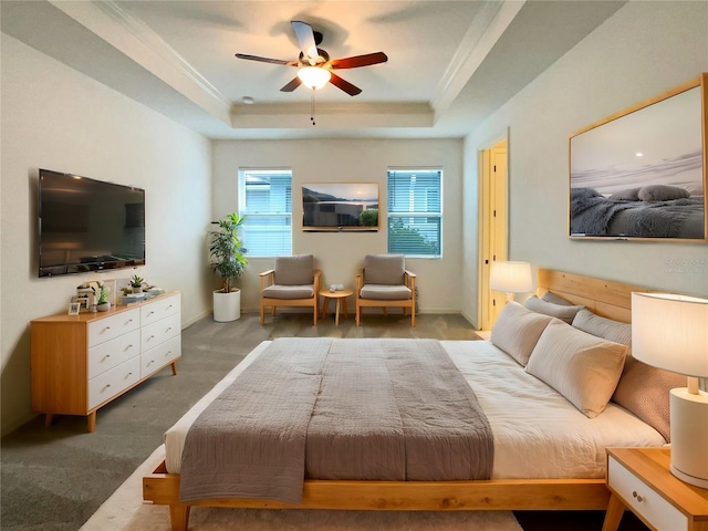 carpeted bedroom featuring a raised ceiling, ceiling fan, and crown molding