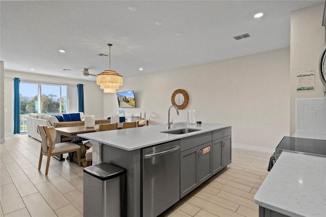 kitchen with sink, stainless steel dishwasher, pendant lighting, light hardwood / wood-style floors, and a center island with sink